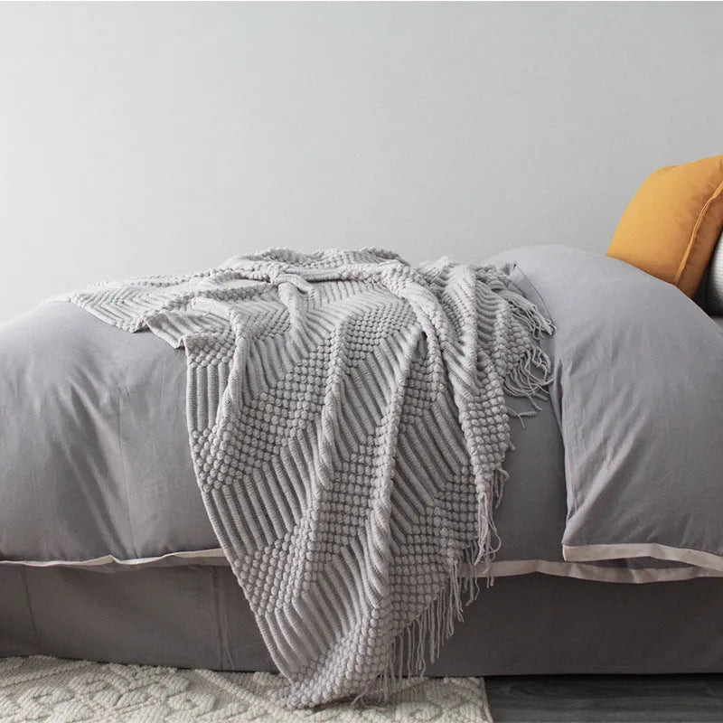 Small grey polyester nap blanket folded, showing its size and texture.
