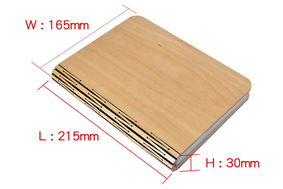 Walnut cover LED book light open at an angle showing white light pages on a surface