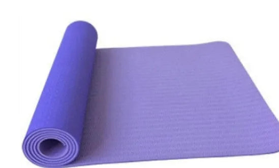 6mm TPE beginner yoga mat in black, rolled on wooden floor with textured non-slip surface visible