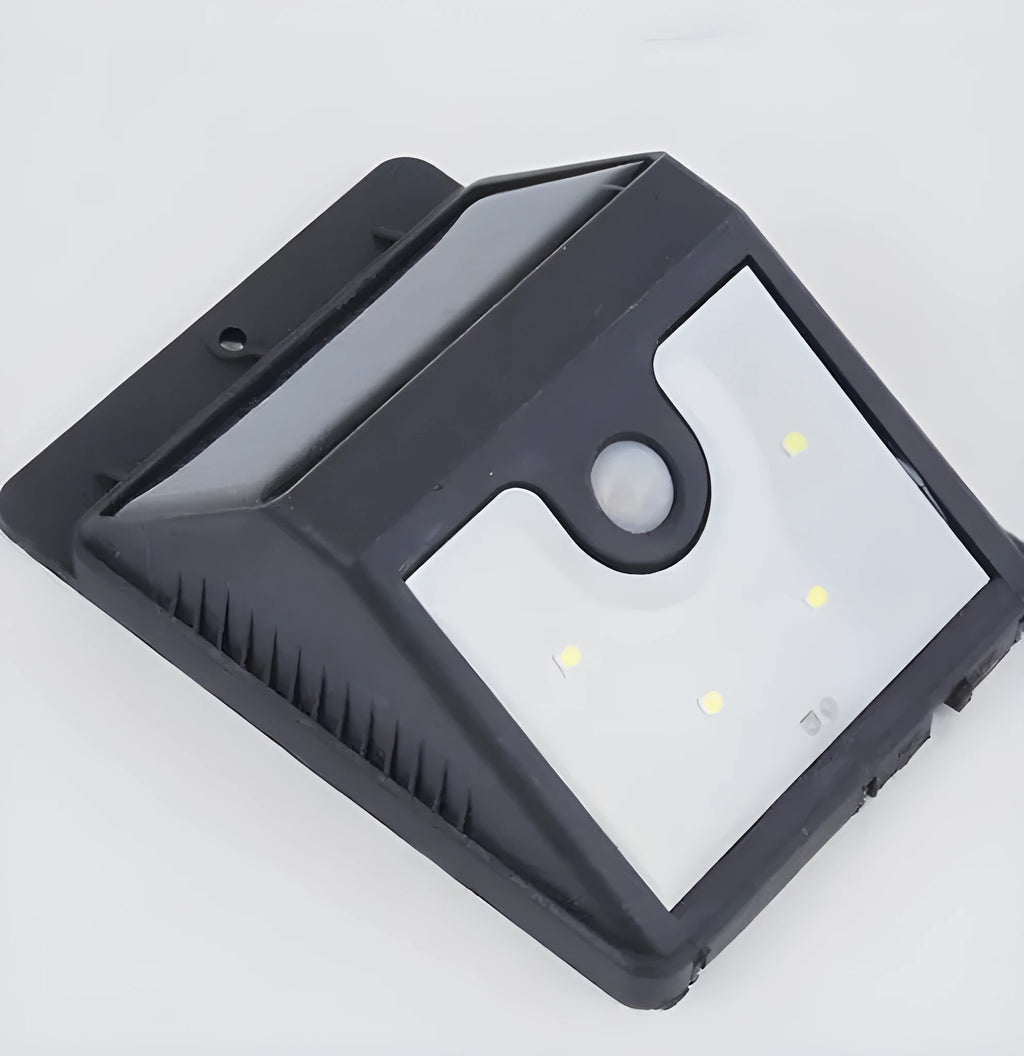 Set of four white outdoor solar security lights with motion sensors mounted on a wall.