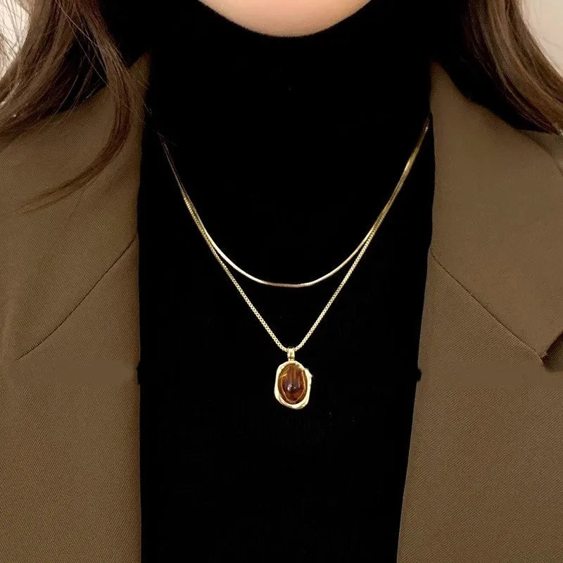 Women's geometric alloy pendant necklace with polished finish and gold copper clavicle chain on neutral background