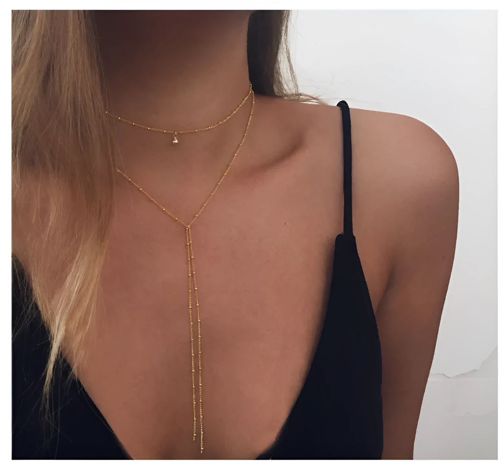 Multilayer lariat necklace in gold alloy plating with two layered strands and extension chain on white background