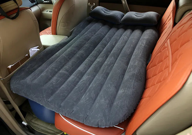 Black inflatable car bed with flocked material laid out in a five-seater vehicle boot.