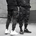 Men's black cotton cargo joggers with drawstring waist and side velcro pockets, loose harem fit
