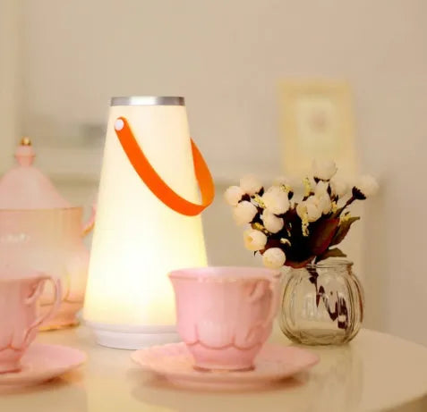 White rechargeable LED lantern night light on a wooden bedside table.