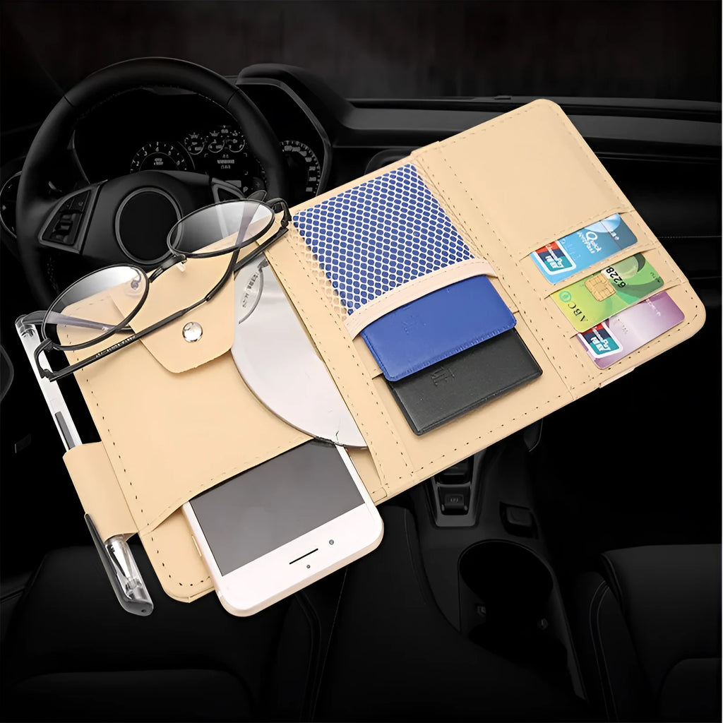 Beige car sun visor storage bag with seven open pockets, zip pocket, sunglasses clip, and pen holder on vehicle visor