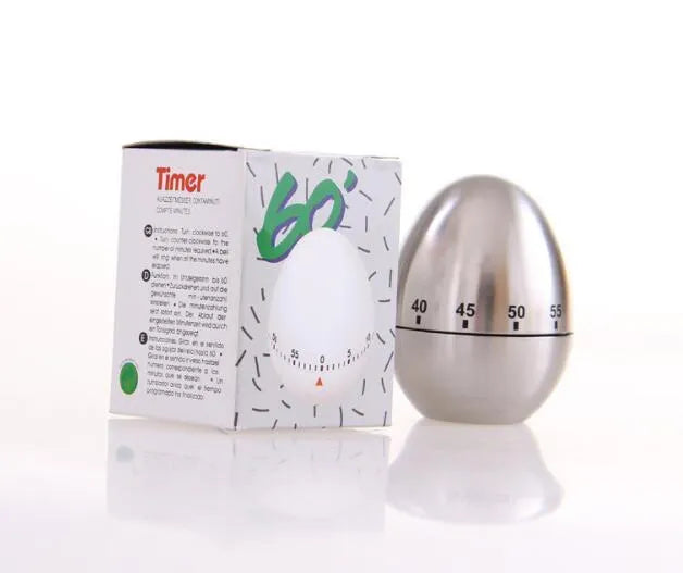 Stainless steel egg-shaped mechanical kitchen timer on a kitchen worktop.