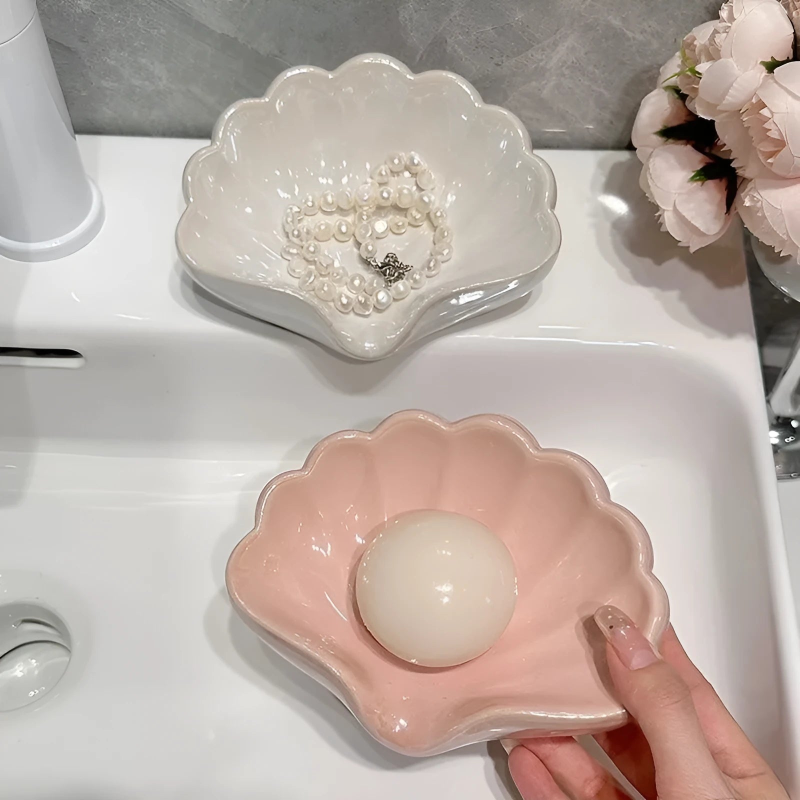 White shell-shaped plastic soap dish for bathroom countertop.