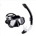 Black diving goggles with clear anti-fog lens, polycarbonate frame, and blue silicone skirt on an adjustable strap.