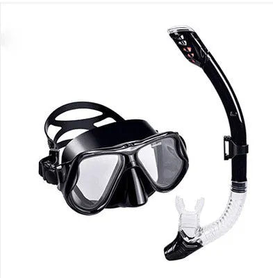 Black diving goggles with clear anti-fog lens, polycarbonate frame, and blue silicone skirt on an adjustable strap.