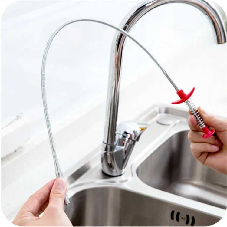 Black sewer dredge spring drain unclogging tool with PP handle next to a kitchen sink