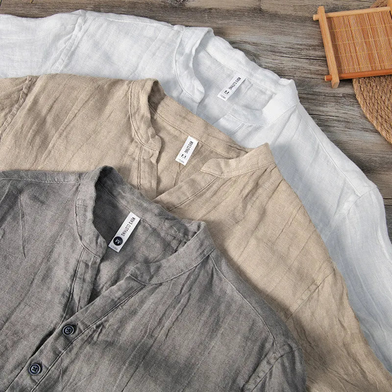 A grey linen short sleeve pullover top with a stripe pattern, laid flat.