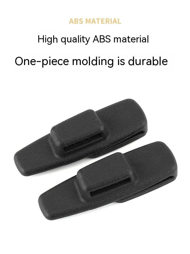 Two black ABS plastic car seatbelt stopper clips for adjusting length and preventing neck pinch.