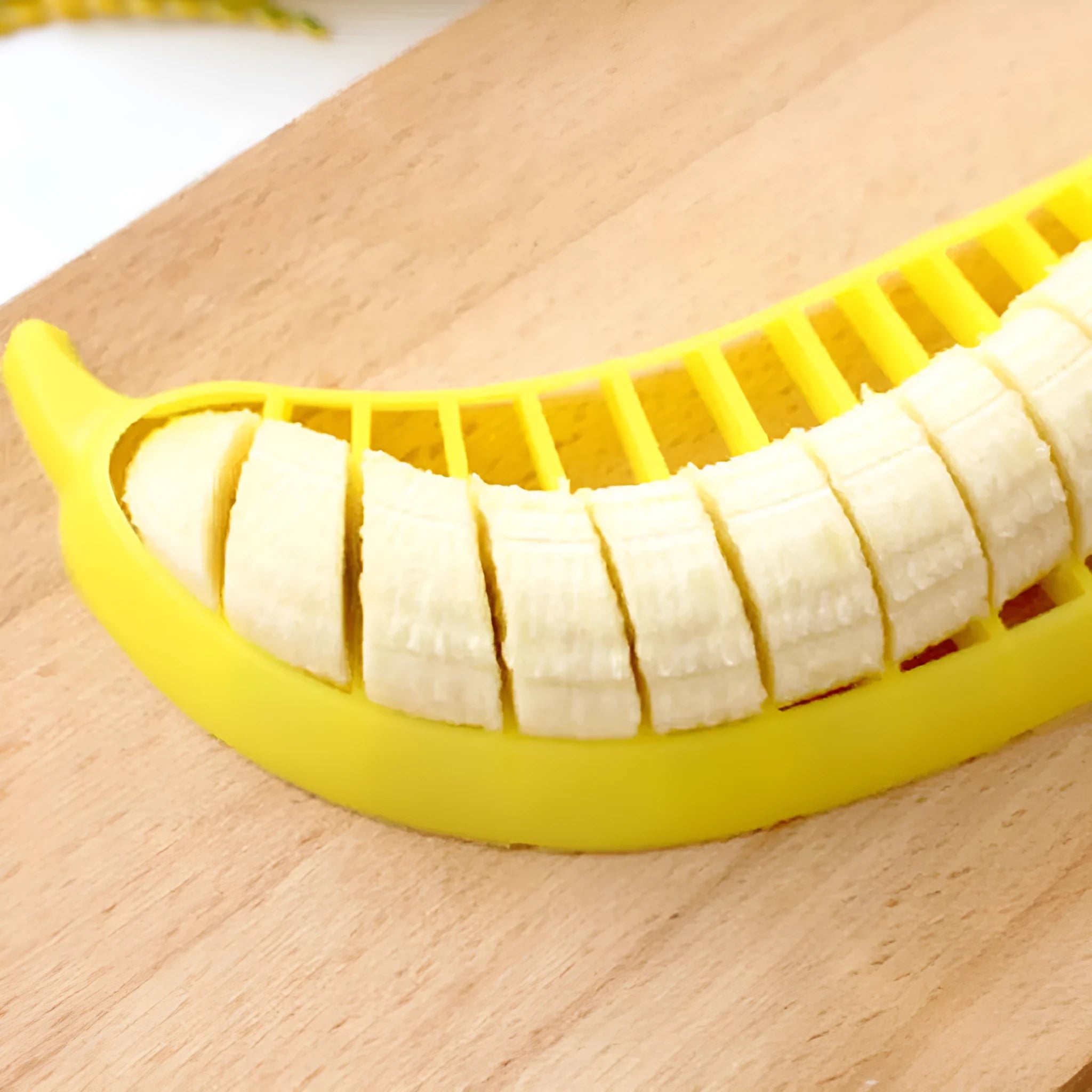 Yellow banana slicer made from food-grade PP plastic on a light background