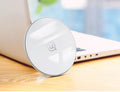 Black or white glass disc wireless charger on a surface, showing status light.