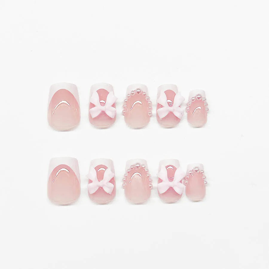 Short white French style press-on nails with bow, tulip, and leopard print designs.