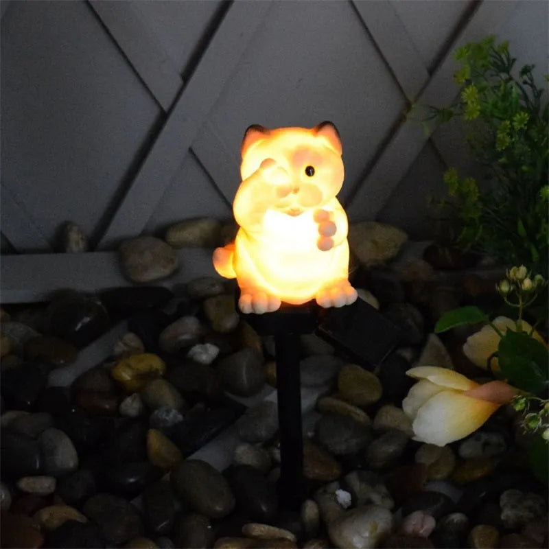 Brown cat-shaped resin solar light standing in a garden