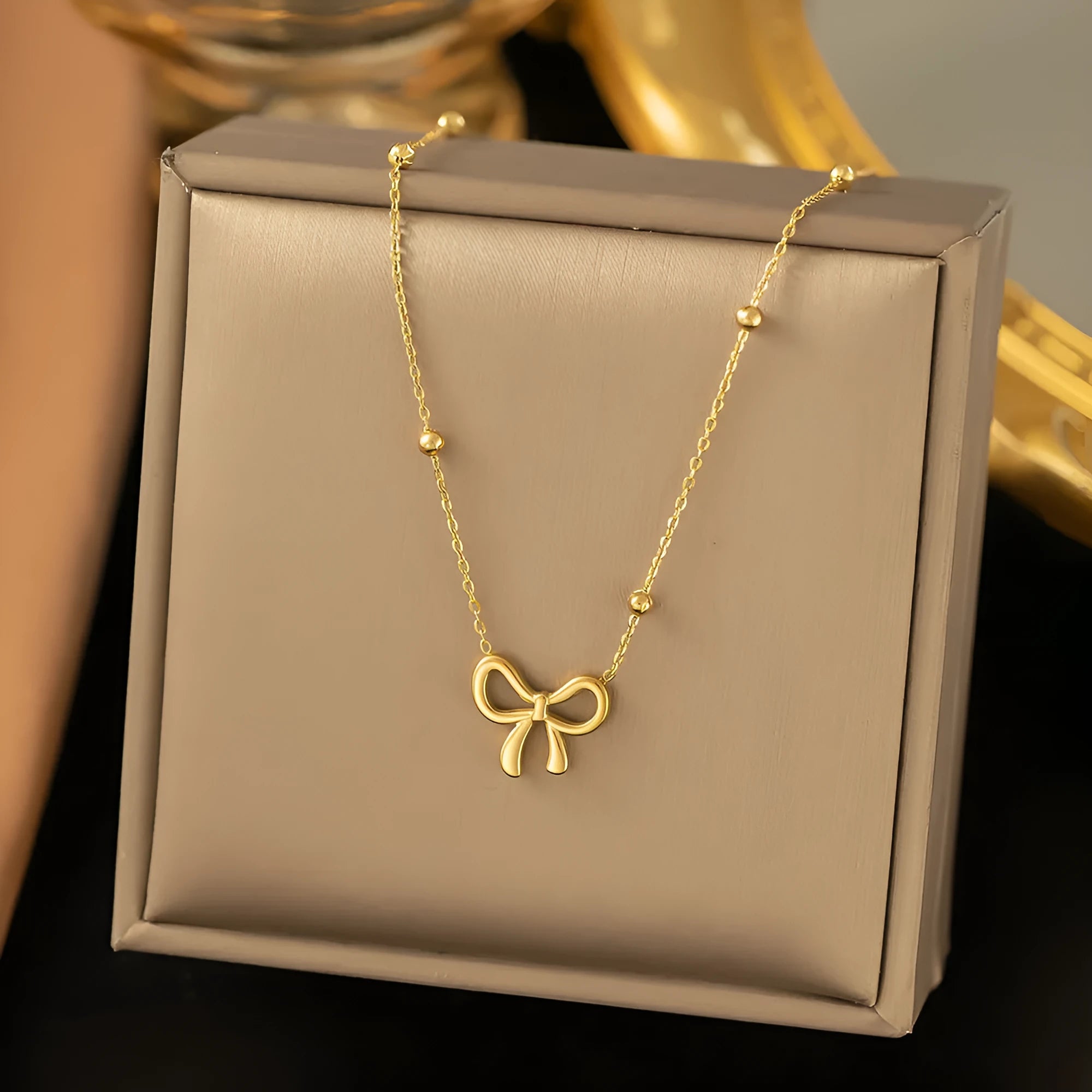 Gold electroplated bow necklace with cross chain design on adjustable 41-50cm chain