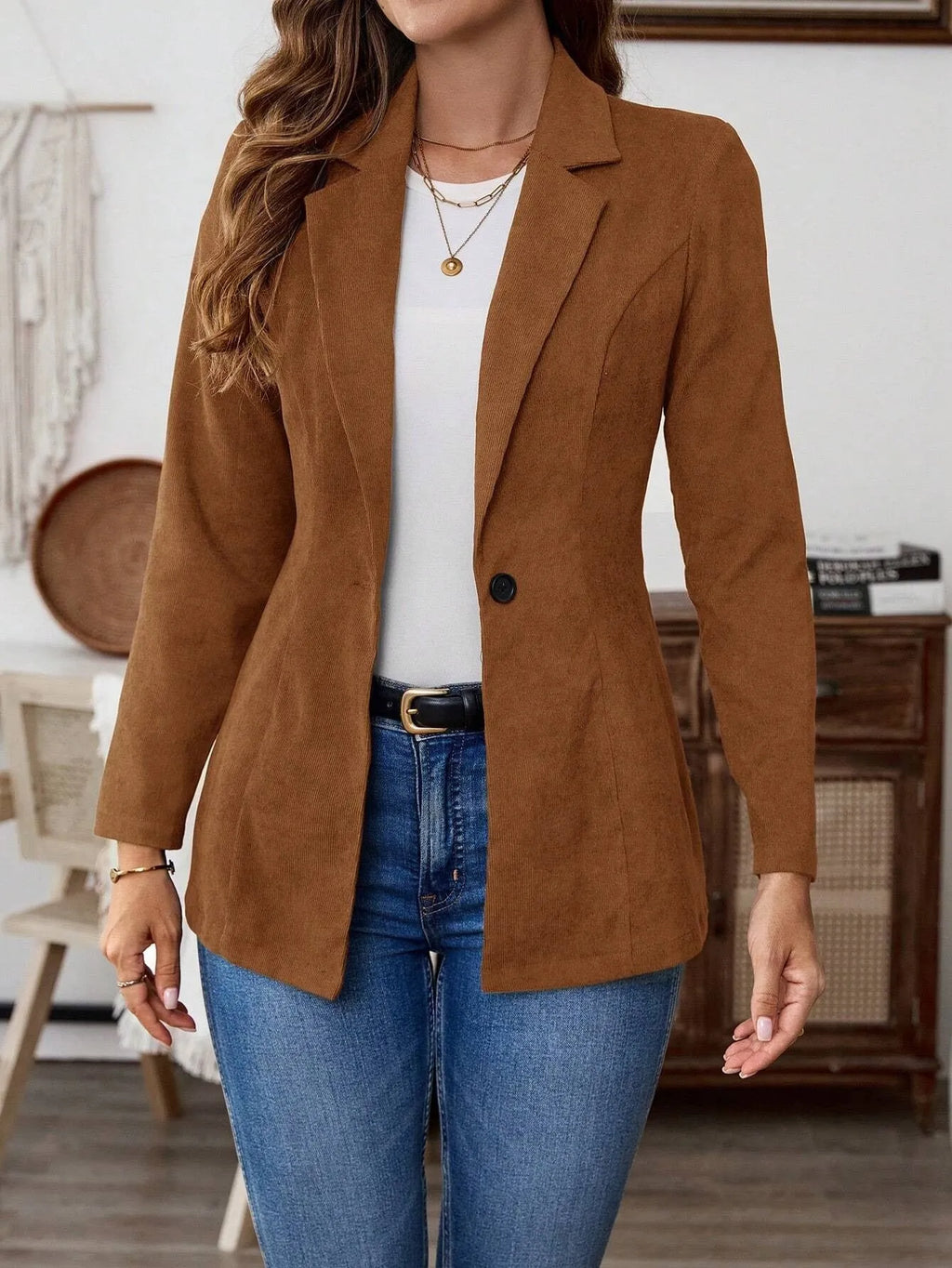 A brown men's single-breasted lapel suit coat with long sleeves on a hanger.