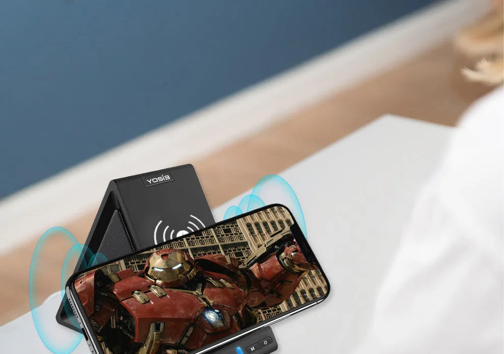 Black portable Bluetooth speaker with integrated mobile phone stand and wireless charging function.
