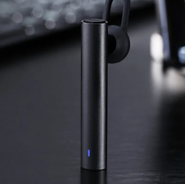 Compact black and white wireless Bluetooth headset showing size scale.