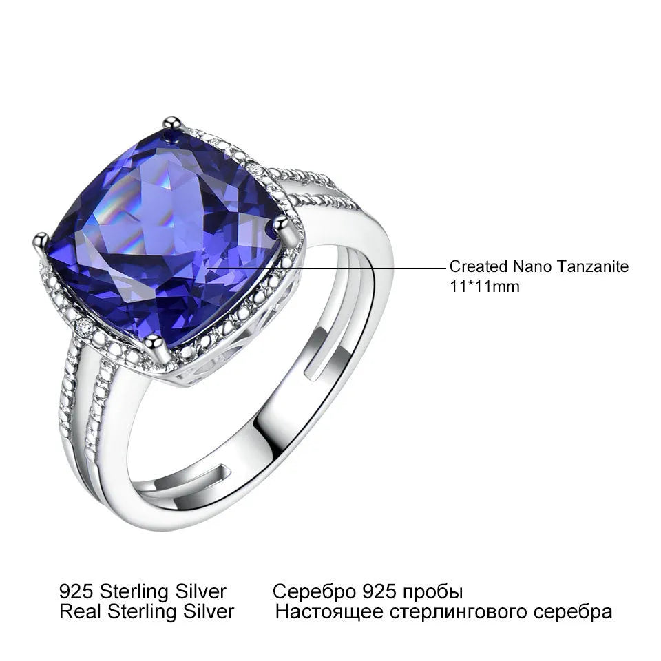 Blue tanzanite stone set in a sterling silver women's ring on a grey background.