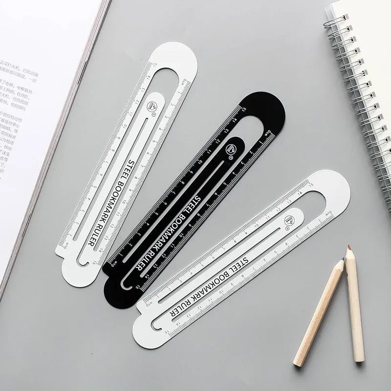 Black and white two-sided 12cm steel ruler on a wooden desk.