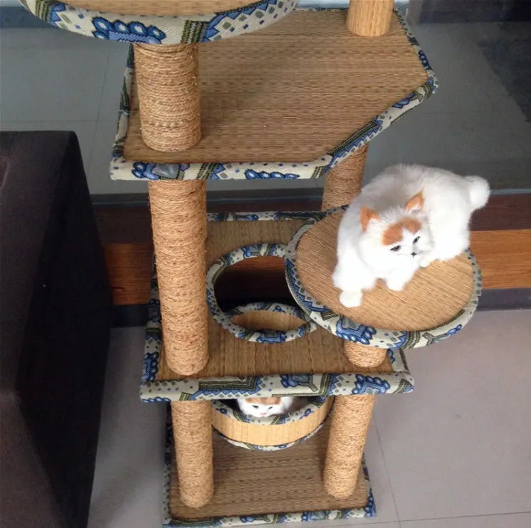 Cat playing on a natural wheat straw scratch board climbing frame with multiple levels