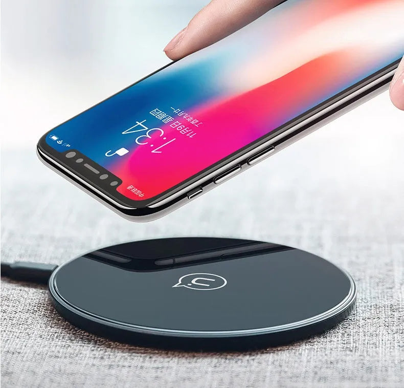 Black or white glass disc wireless charger on a surface, showing status light.