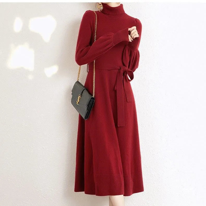 Rose red loose turtleneck knit dress with long sleeves and a flared skirt hem on a hanger.