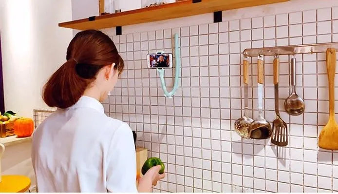 Flexible worm-style lazy bracket mobile phone holder with long silicone arm and black rubber suction cup base.