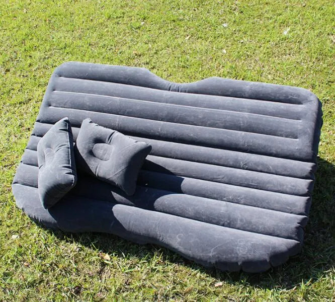 Black inflatable car bed with flocked material laid out in a five-seater vehicle boot.