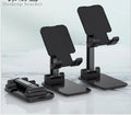 Black desk mobile phone holder made of silicone and ABS plastic on a wooden desk