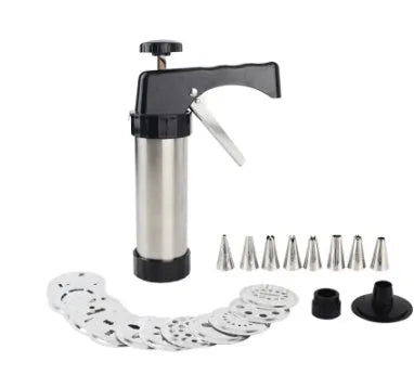 Stainless steel biscuit press machine with assortment of cookie moulds and piping nozzles on a kitchen worktop