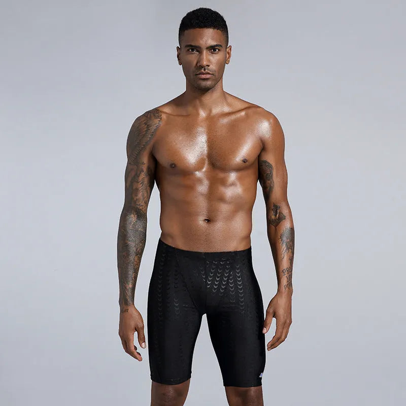 Men's solid colour swimming trunks in shark skin polyester fabric for surfing.