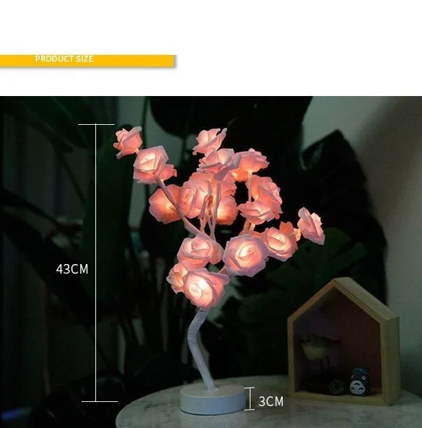 White and red rose flower shaped USB battery LED table lamp with warm white light on a table.
