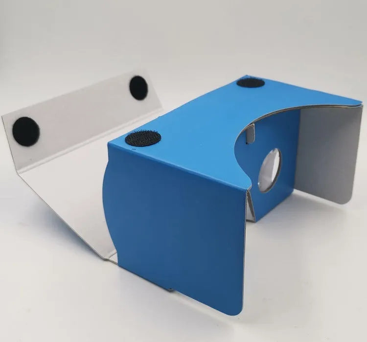 Foldable pink and white VR cardboard glasses headset for smartphones with adjustable strap and 3D lenses.