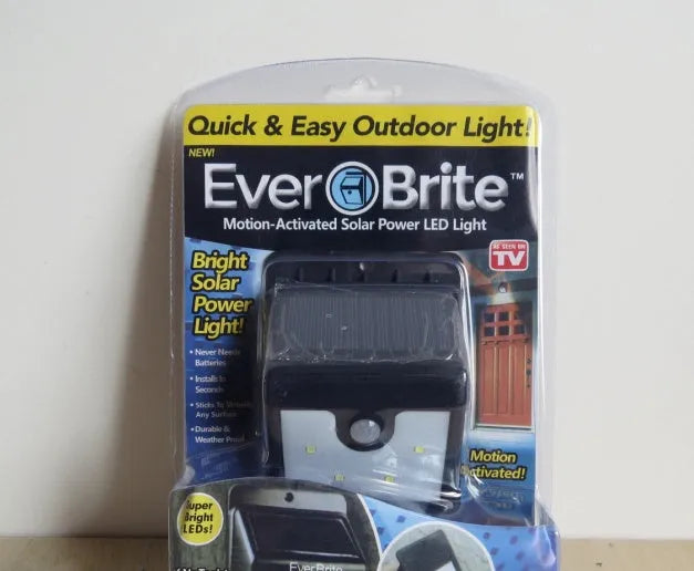 White outdoor solar motion sensor light with four LEDs and an integrated solar panel on top