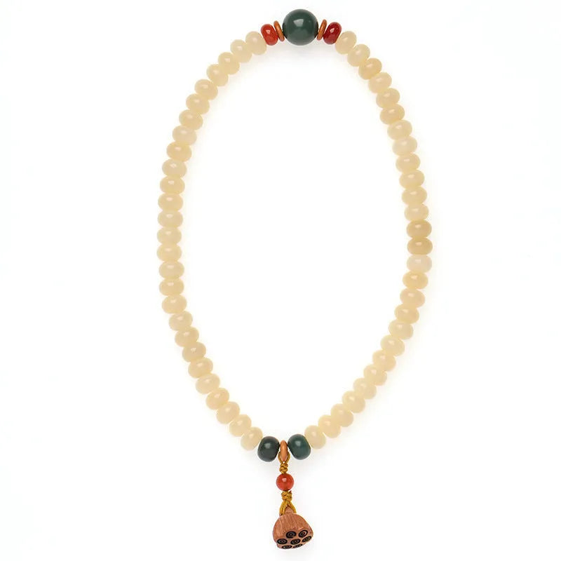 Cream topaz coloured wooden Bodhi root bracelet with flat round beads on a wrist.