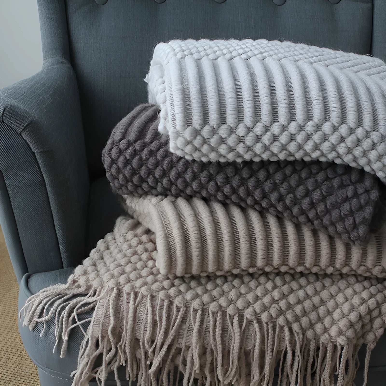 Small grey polyester nap blanket folded, showing its size and texture.