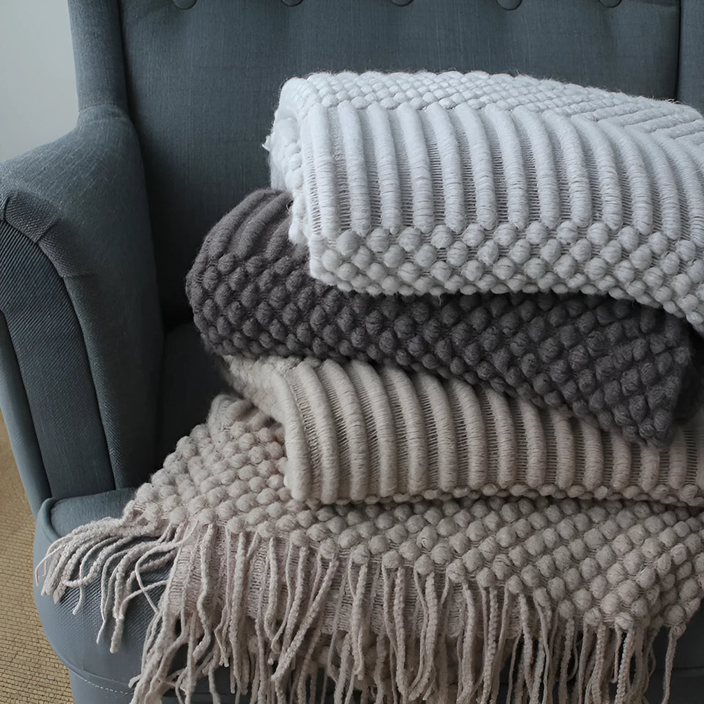 Small polyester fibre throw blanket in dark grey, shown folded, dimensions 127cm by 170cm.