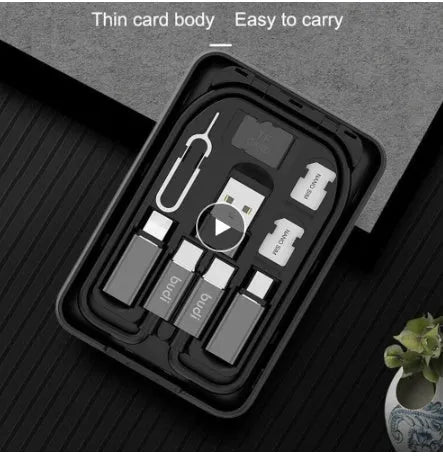 Black budi multi-functional power bank with cables and SIM kit on a table