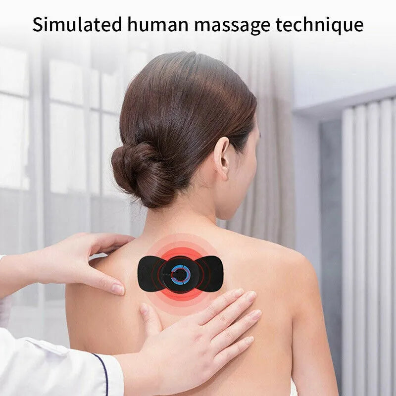 Black HQ-185 mini electric shoulder and neck massager with massage patch, shown next to a ruler for scale.