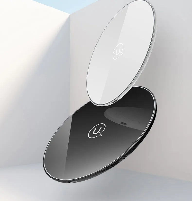 Black or white glass disc wireless charger on a surface, showing status light.