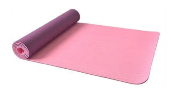 6mm TPE beginner yoga mat in black, rolled on wooden floor with textured non-slip surface visible