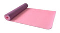 6mm TPE beginner yoga mat in black, rolled on wooden floor with textured non-slip surface visible
