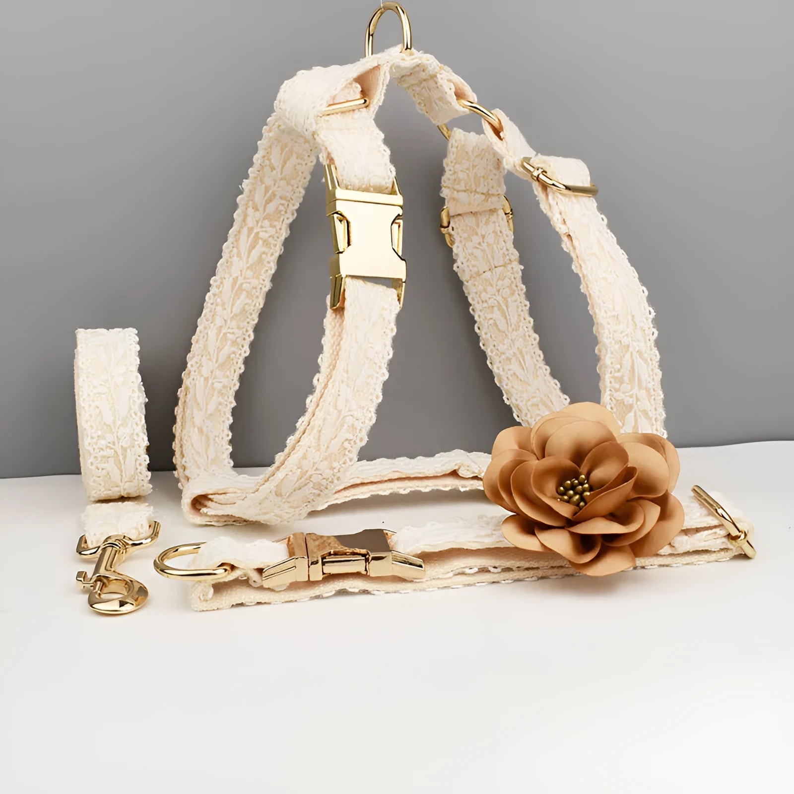 Four-piece dog wedding set with lace vest, matching collar, flower headband, and leash on white background