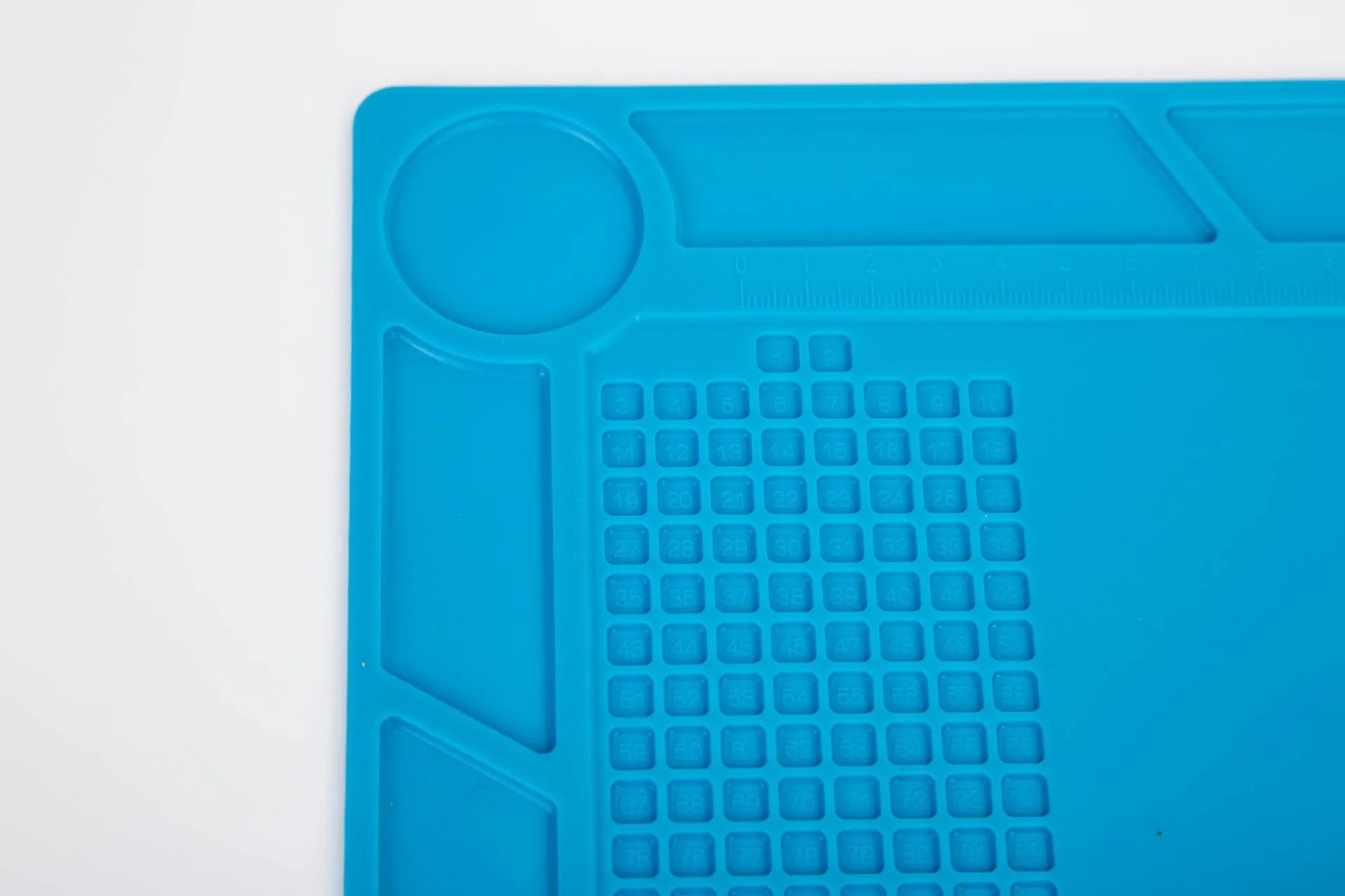 Blue silicone anti-skid watch repair mat lying flat on a workbench.
