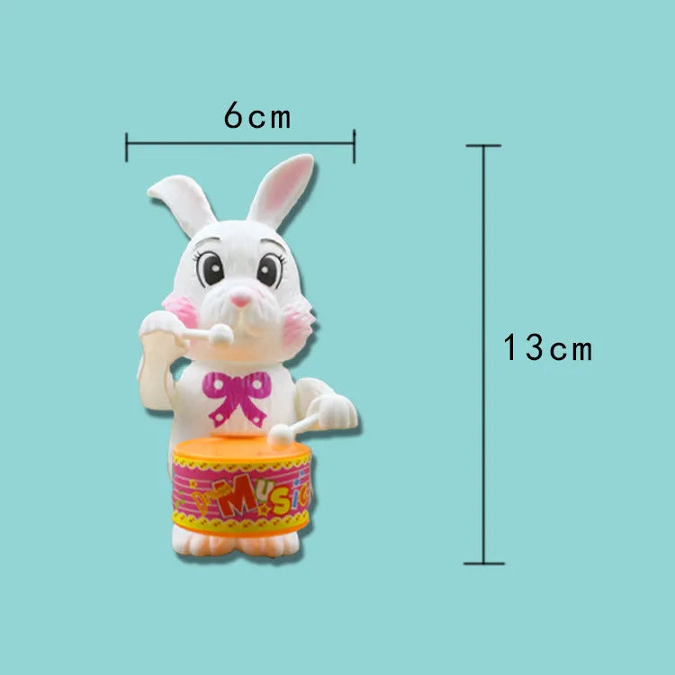 Cartton white plastic rabbit drumming clockwork wind-up toy on white background, 6x13cm