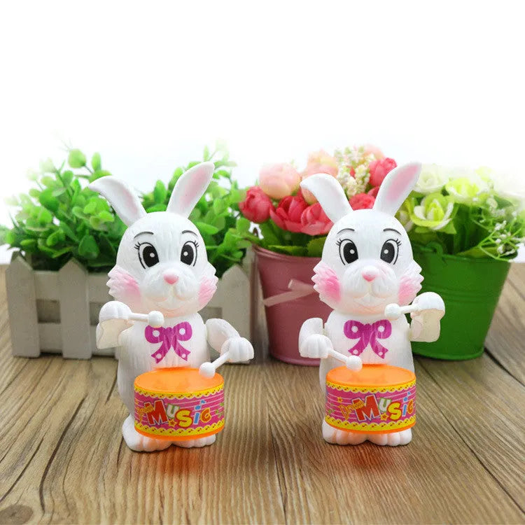 Cartton white plastic rabbit drumming clockwork wind-up toy on white background, 6x13cm